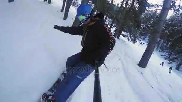 Filmagem em câmera lenta do homem snowboarder cavalgando pela floresta — Vídeo de Stock