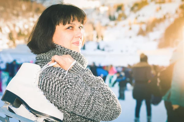 Mujer madura feliz sostiene patines en pista de hielo Medeo —  Fotos de Stock