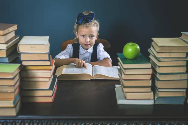 Smart skola flicka läsa en bok på biblioteket — Stockfoto