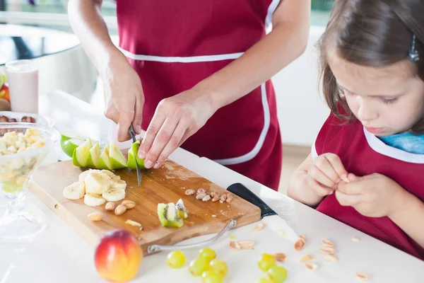 Närbild flicka matlagning med hennes mor, hälsosam mat — Stockfoto