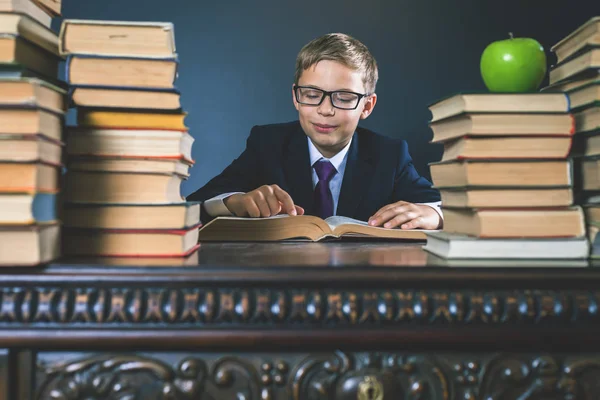 Intelligens iskola fiú Olvasson egy könyvet a könyvtárban — Stock Fotó