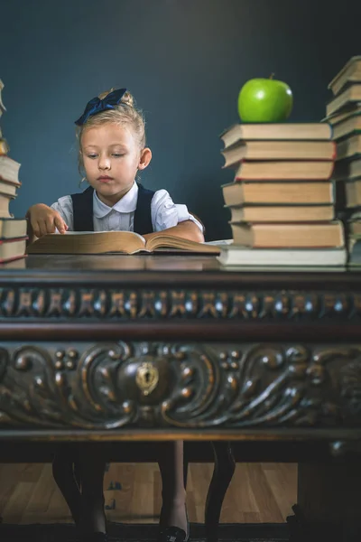 Smart skola flicka läsa en bok på biblioteket — Stockfoto