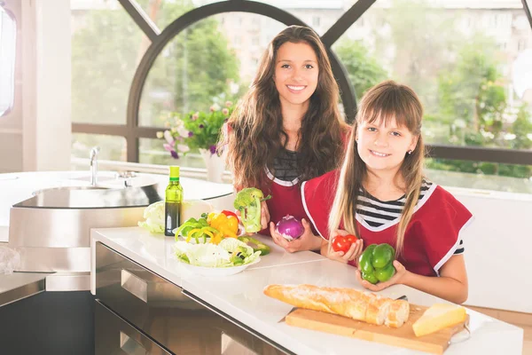 Keluarga bahagia gadis-gadis muda memasak. Makanan vegetarian di dapur — Stok Foto