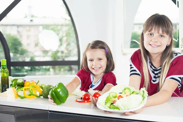 Söt liten flicka matlagning med hennes syster, hälsosam mat — Stockfoto
