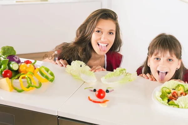 Divertida familia haciendo sonriente cara con ensalada . — Foto de Stock