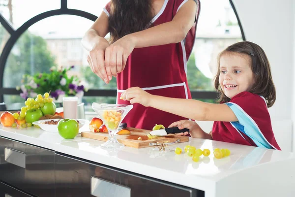 Söt liten flicka matlagning med hennes syster, hälsosam mat — Stockfoto
