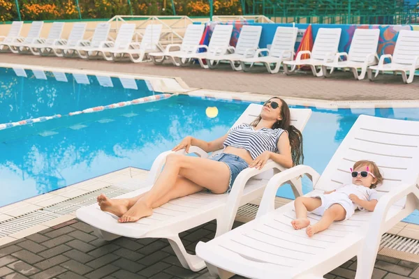 Eindeloze zomer. Schattige baby en moeder ontspannen op de zonnebank — Stockfoto