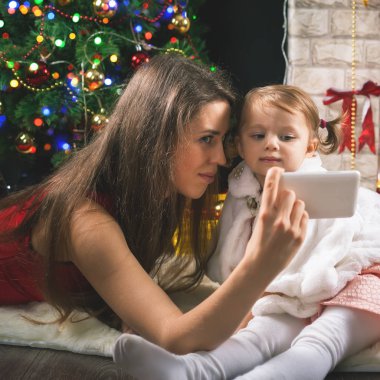 Çocuk ve anne selfie üstünde hareket eden telefon, Noel ağacı yapmak