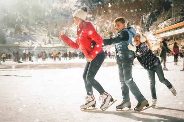 Gelukkig gezin buiten schaatsen op ijsbaan. Winteractiviteiten — Stockfoto