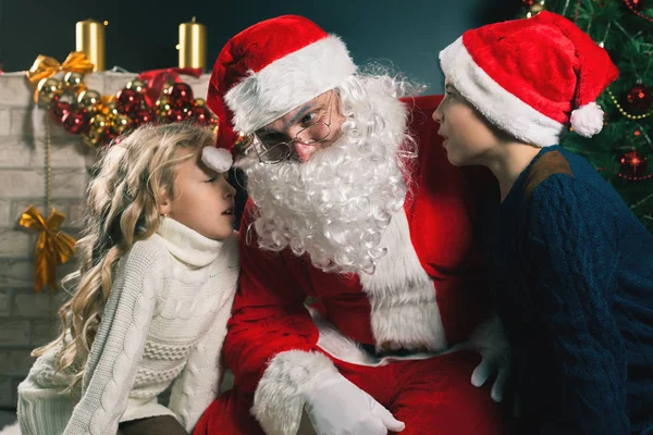 Crianças em torno de Papai Noel dizer-lhe que deseja, véspera de Natal — Fotografia de Stock