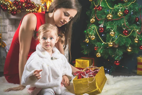 Bambino carino e mamma che decorano un albero di Natale. Palle rosse . — Foto Stock