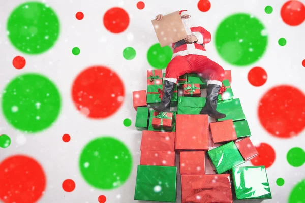 Santa sentado en grandes cajas de regalo y lectura lista de deseos —  Fotos de Stock