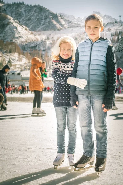 Gelukkige kinderen schaatsen op ijsbaan buiten — Stockfoto