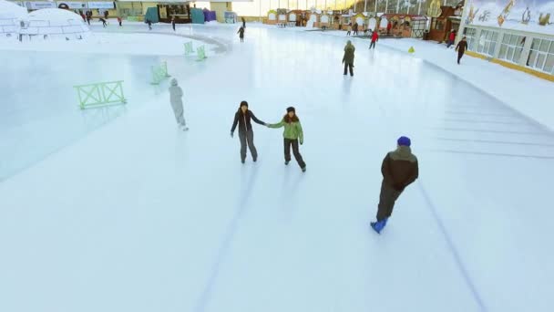 4k Filmmaterial junge Frauen beim Eislaufen im Freien auf der Eisbahn medeo — Stockvideo