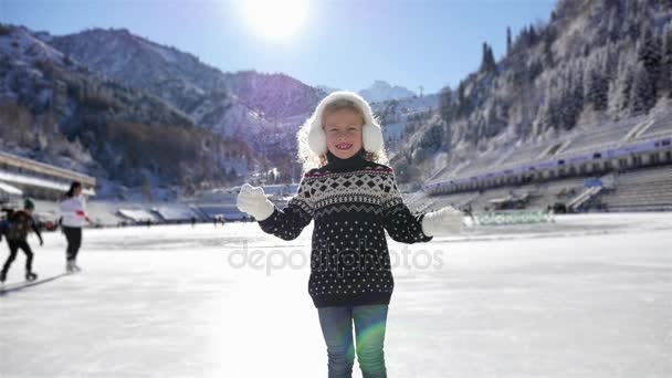 Chica feliz patinaje sobre hielo en la pista al aire libre en invierno . — Vídeos de Stock