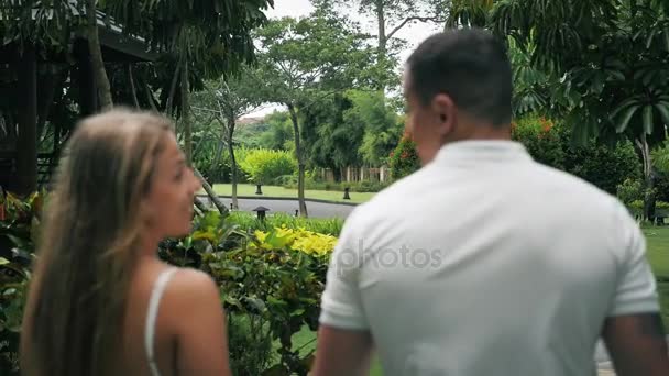 Happy couple traveling in near hotel resort. Couple holds hands — Stock Video
