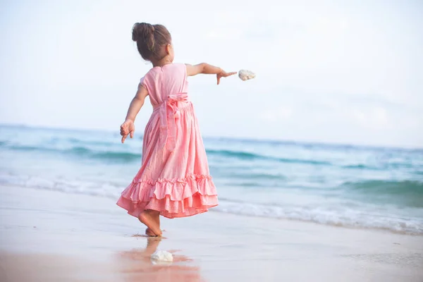 Menina joga uma pedra no mar . — Fotografia de Stock