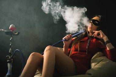 Genç, güzel bir kız duman bir nargile Club