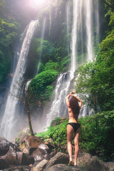 Ung sexig kvinna tittar på vattenfall i djungeln. Ekoturism — Stockfoto
