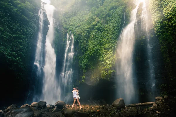 Удивительный романтический вид счастливой пары возле красивого грандиозного водопада — стоковое фото
