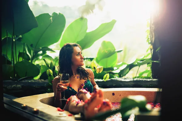 Mujer relajante baño con flores tropicales al aire libre en hotel de lujo —  Fotos de Stock