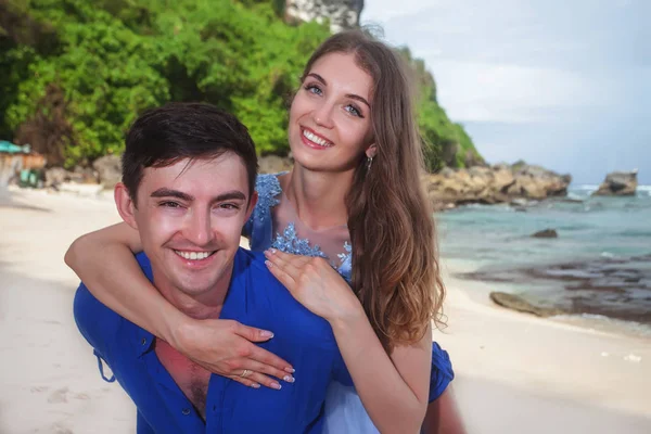Glückliches Paar, am Strand sitzend, hält Händchen — Stockfoto