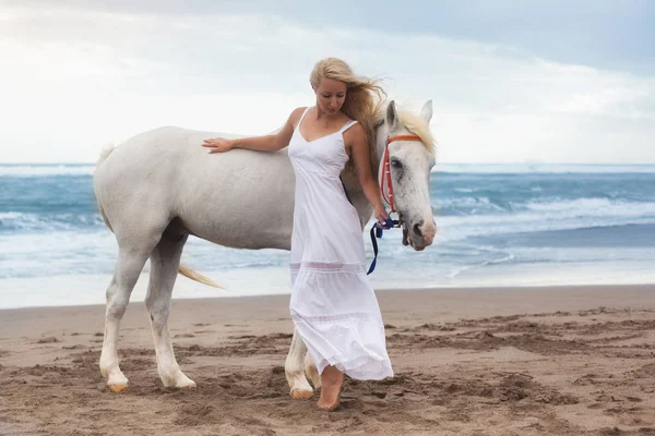 Gyönyörű fiatal nő séta a ló, a strandon, lovaglás — Stock Fotó