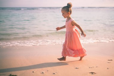 Sahilde güzel küçük kız. Güneş kremi krem çocuklar için.