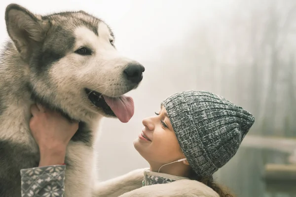 Imagen de la joven con su perro, Alaska Malamute, al aire libre —  Fotos de Stock