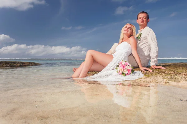 Casamento casal acaba de se casar deitado na água perto da praia — Fotografia de Stock