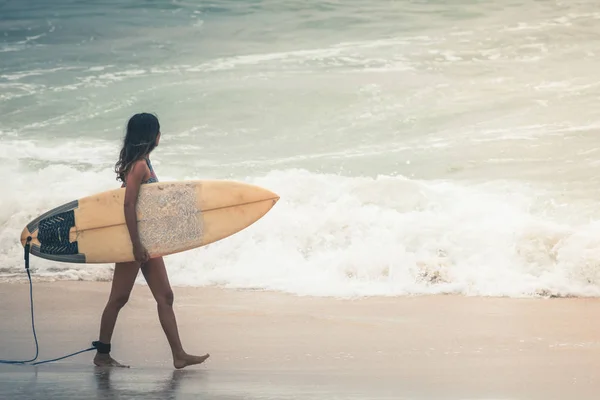 Surfař s Surf bude surfovat místě, chůze v blízkosti pláže. — Stock fotografie