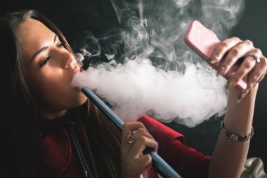 Genç, güzel bir kız duman nargile Club, selfie cep telefonu