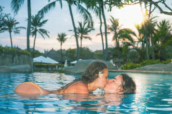 Sexy pareja, cuerpo en la piscina Palm Resort cerca del hotel . —  Fotos de Stock