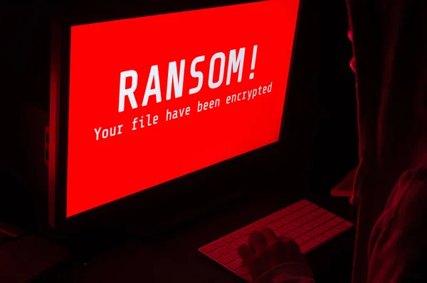 Tela do computador com ataques ransomware alerta em vermelho e um homem k — Fotografia de Stock