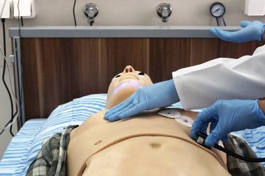 Tıbbi simülasyon yordamı. Oskültasyon simüle hasta olarak kukla bir manken için performans bir doktor olarak tıp öğrencisi