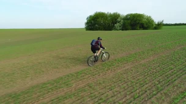 Cyklist rider upp på fältet. — Stockvideo