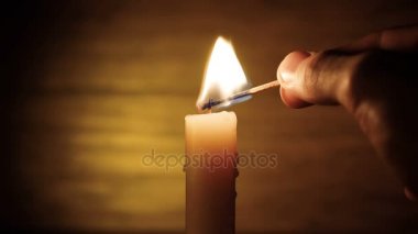 El bir mum koyu kahverengi zemin üzerinde ışıklar.