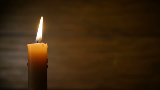 Hořící svíčka na tmavém pozadí — Stock video