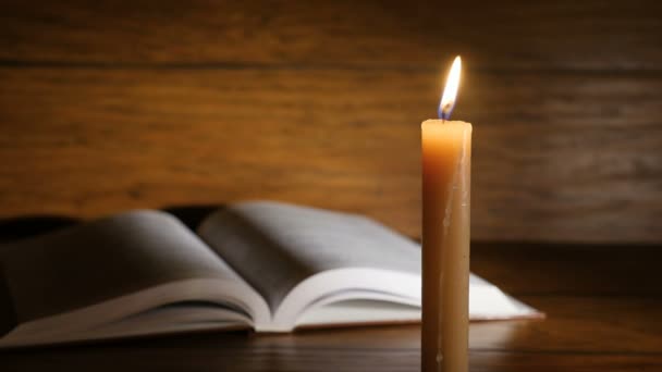 Старая редкая священная книга со свечами впереди — стоковое видео