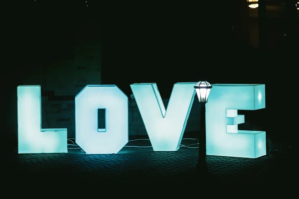 Άναψε τα μεγάλα μπλε γράμματα αγάπη με σκούρο φόντο — Φωτογραφία Αρχείου