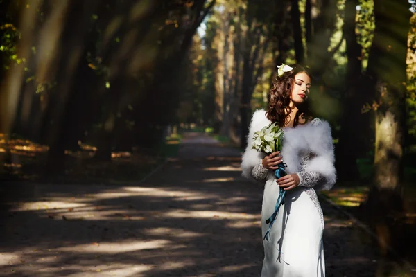 Bride looks sensual holding a lily bouquet — ストック写真