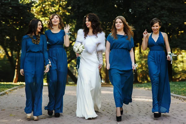 Bride and girls in blue walking around the park — Stock Photo, Image