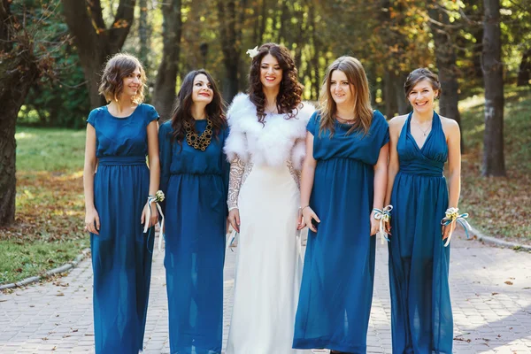 Bride with bridesmaid standing straight and laughing in the park — Stock Photo, Image