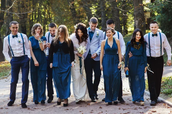 Groomsmen and bridesmaids having fun while walking in the park — Stock Photo, Image