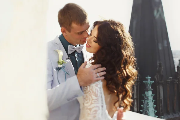 Verlobter küsst Braut, die seine Hand auf ihre Schulter hält — Stockfoto