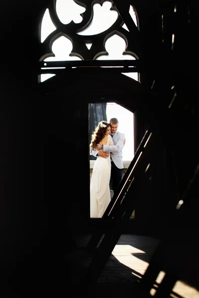 Abraço de noiva e noivo na porta para o telhado da catedral gótica — Fotografia de Stock