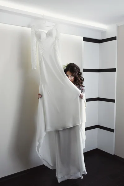 Hübsches Mädchen spielt mit einem weißen Kleid — Stockfoto