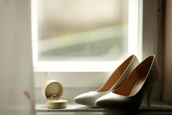 Beautiful luxury wedding rings and bride heels — Stock Photo, Image