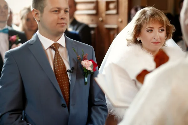 Belos recém-casados na cerimônia de casamento na igreja — Fotografia de Stock