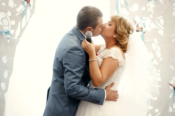 Glada vackra kysser nygifta — Stockfoto